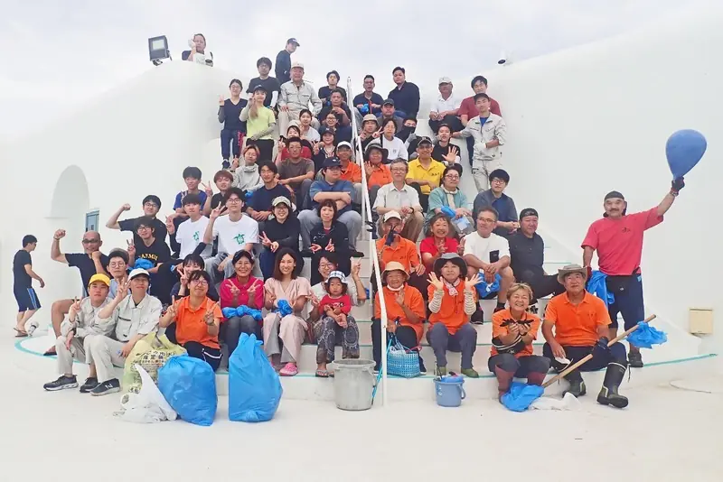 階段状の広場に並ぶ、鹿児島大学水産学部の学生と海謝美のメンバー